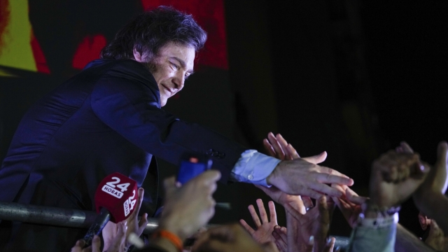 Javier Milei greets supporters outside his campaign headquarters in Argentina.