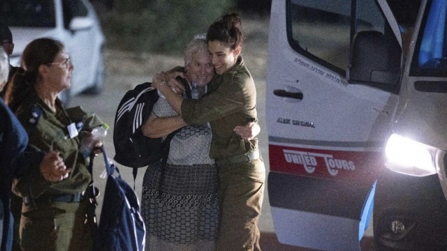 Margalit Mozes, a released Israeli hostage, walks with an Israeli soldier on Nov. 24.