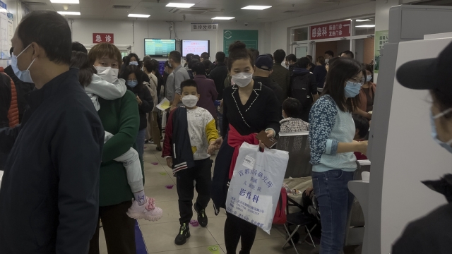 Parents with their children wait at a crowded holding room of a children's hospital in Beijing.