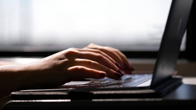 A person types on a computer